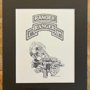 Może przedstawiać: Czarno-biały rysunek piórem żołnierza z karabinem, z napisami "RANGER" i "1st RANGER BN". Grafika jest oprawiona w białą matę i czarną ramę.