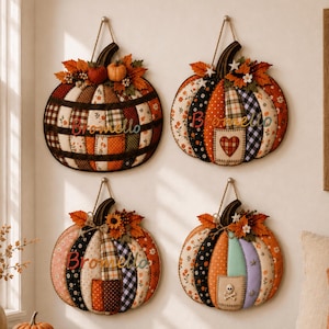 Puede incluir: Cuatro adornos de pared de tela con forma de calabaza y diseños de patchwork en tonos naranja, marrón, negro y blanco. Cada calabaza está decorada con hojas de otoño y bayas artificiales. Tres calabazas llevan el texto bordado Bromello.