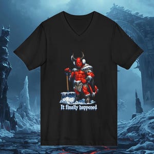 Puede incluir: Camiseta negra con cuello en V con un personaje de diablo rojo con cuernos, orejeras y una pala de nieve. El diablo está cubierto de nieve y hielo. El texto "It finally happened" está impreso en blanco.