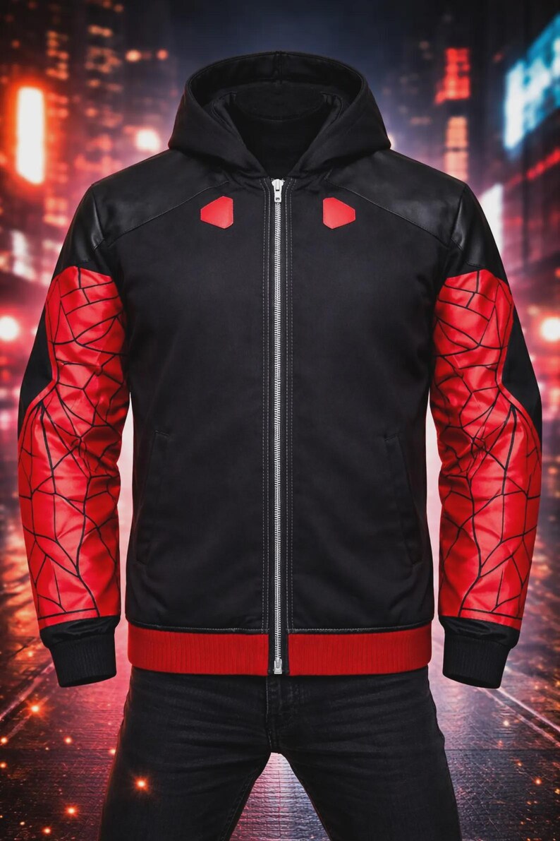 May include: Black zip-up hooded jacket with red accents. The sleeves feature a red web design, and the jacket has a red band at the waist and cuffs. The shoulders have black panels and red geometric shapes.