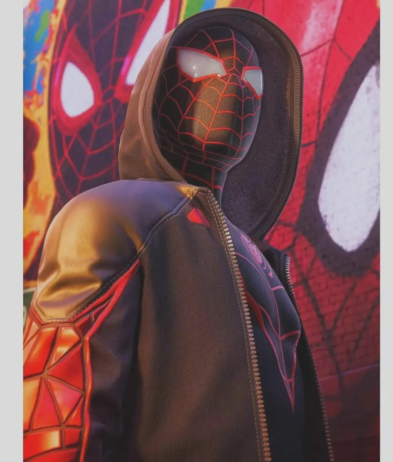 May include: A black and red Spider-Man costume with a hooded jacket. The mask has white eye lenses and a red web pattern. The jacket features red geometric designs on the sleeves and a zipper closure. A Spider-Man mural is in the background.