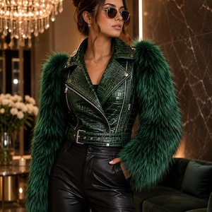 Pode incluir: Um casaco de motociclista verde-escuro com textura de crocodilo, com mangas compridas com acabamento em pelo sintético verde, gola de lapela, fechos de metal prateado e um cinto com fivela a condizer na cintura, combinado com calças pretas.