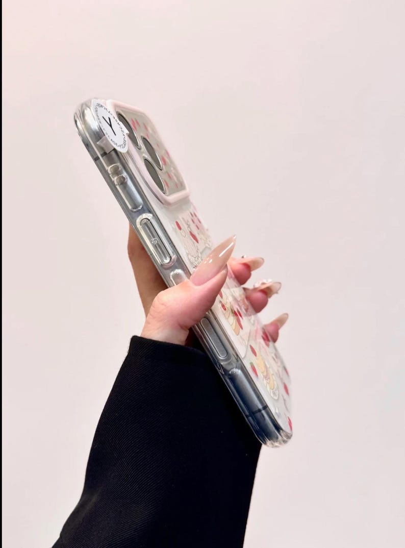 May include: Clear phone case with a floral design featuring red and yellow flowers. The case has a white border and a clear back, offering protection while showcasing the phone's design. A white sticker with a black "Y" is on the top left corner.