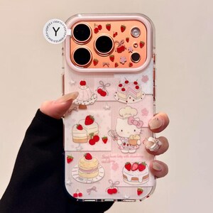 May include: Clear phone case with a pink frame and a design featuring cakes, strawberries, and a cartoon cat. The case has a decorative pattern of pink stars and the text "Sweet heart kitty with strawberry and cherry".