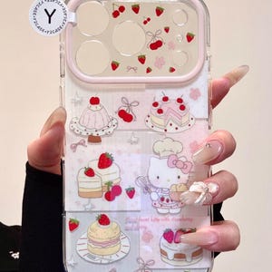 May include: Clear phone case with a pink border and a design featuring strawberries, cherries, and cakes. The case includes a cartoon image of Hello Kitty. The text on the case reads "Sweet heart kitty with strawberry and cherry."