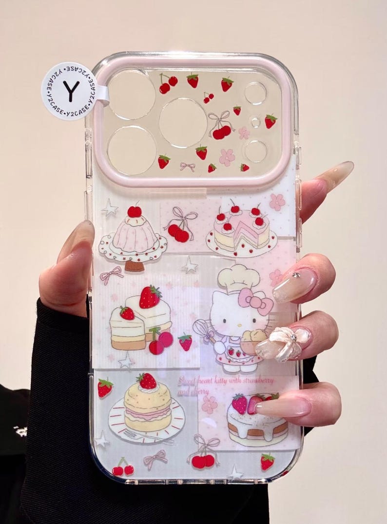 May include: Clear phone case with a pink border and a design featuring strawberries, cherries, and cakes. The case includes a cartoon image of Hello Kitty. The text on the case reads "Sweet heart kitty with strawberry and cherry."