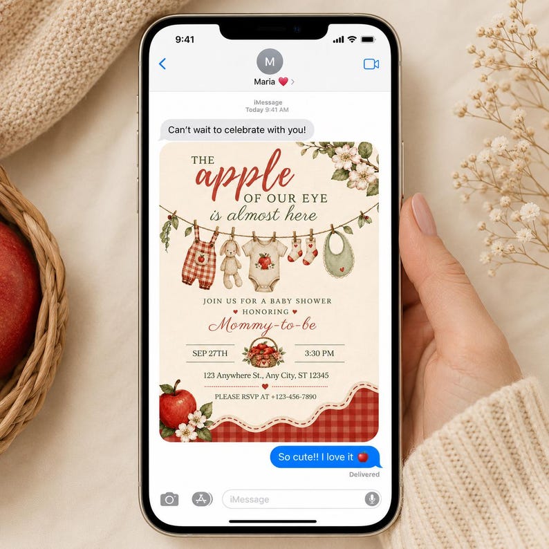 May include: A digital baby shower invitation displayed on a smartphone screen featuring an apple theme. The text reads The apple of our eye is almost here, Join us for a baby shower honoring Mommy-to-be, Sep 27th, 3:30 PM, 123 Anywhere St., Any City, ST 12345, and Please RSVP at +123-456-7890.