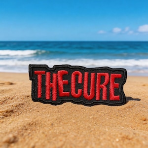 May include: A white ceramic mug with a black handle and the text "But First, Coffee" in a bold, black font. The mug is set against a blurred background, suggesting a cozy setting.