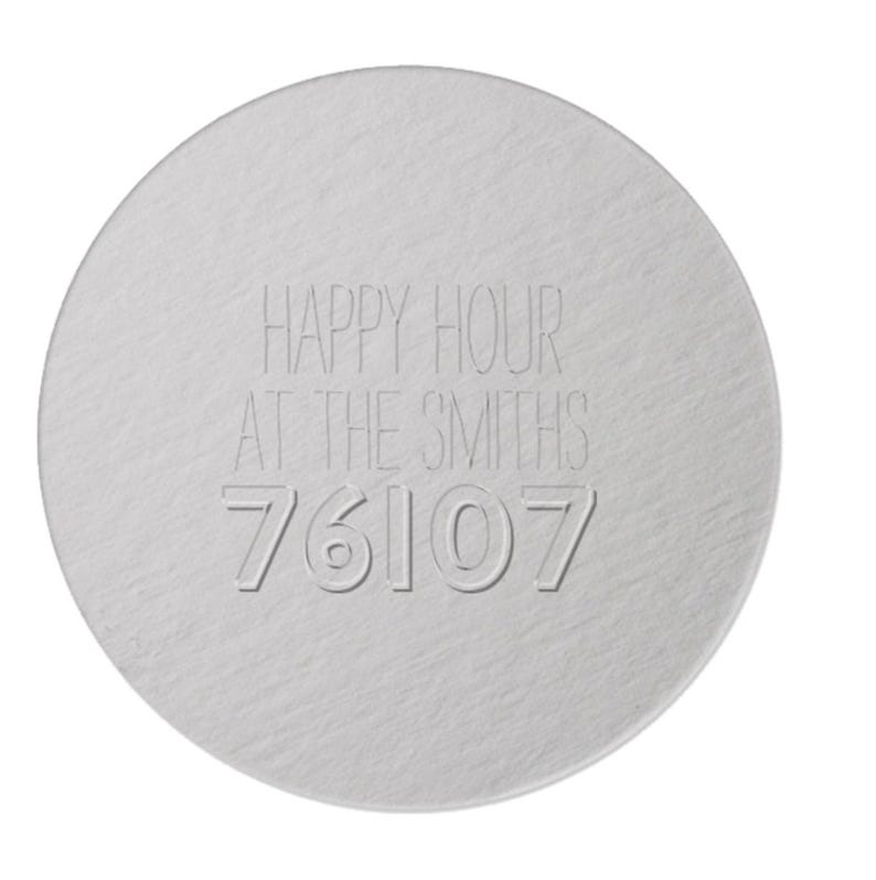 K&ouml;nnte beinhalten: Ein runder, silberfarbener Untersetzer mit dem eingravierten Schriftzug "HAPPY HOUR AT THE SMITHS" und der Zahl "76107". Der Untersetzer hat eine strukturierte Oberfl&auml;che.