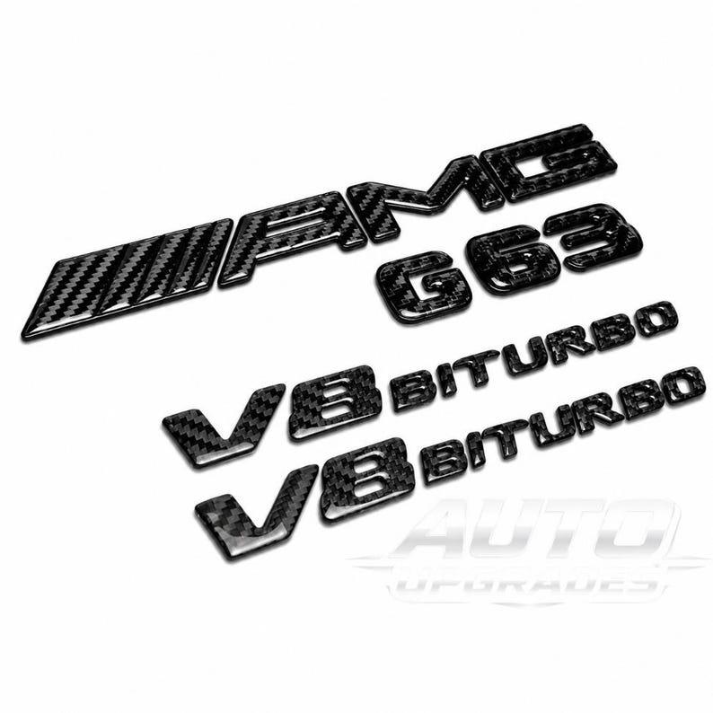 Op de afbeelding: Een set zwarte auto-emblemen in koolstofvezelstijl met de tekst AMG, G63 en twee V8 BITURBO-badges. Deze glanzende, getextureerde stickers zijn ontworpen voor buitengebruik op voertuigen en hebben een duidelijk zichtbaar geweven patroon.