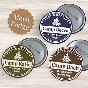 Può includere: Tre spille rotonde con un disegno di un falò e il testo "Let's Get Lit". Le spille sono personalizzate con "Camp Becca", "Camp Katie" e "Camp Bach" insieme a dettagli su luogo e anno. Ogni spilla è dotata di un perno in metallo sul retro.