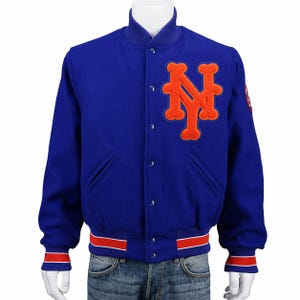 Puede incluir: Chaqueta universitaria azul real con el logo "NY" naranja en el pecho. Cuenta con cierre de botones, bolsillos laterales y puños y cintura a rayas rojas y blancas. Una chaqueta de temática deportiva clásica.