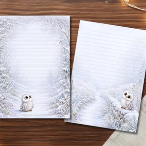 Könnte beinhalten: Zwei Blatt weißes Briefpapier mit horizontalen Linien zum Schreiben. Jedes Blatt zeigt eine winterliche Waldszene mit schneebedeckten Bäumen und einer kleinen, weißen Eule mit großen Augen. Eine Eule sitzt auf dem Boden, die andere auf einer Steinmauer.