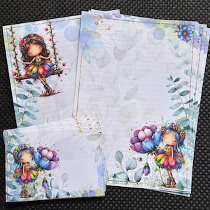 Könnte beinhalten: Ein Schreibwarenset mit linierten Papieren und Umschlägen, verziert mit Illustrationen einer Figur mit blauem Haar, die einen regenbogenfarbenen Rock und einen Blumenkranz trägt, umgeben von Aquarell-Eukalyptusblättern und goldenen Akzenten.
