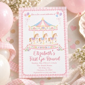 May include: A rectangular invitation card with a pink gingham border featuring a carousel illustration with three horses, balloons, and floral accents. The text reads: Join us for a sweet celebration of Elizabeth's First Go Round, Sunday, May 15th at 1 o'clock, The Smith Home, 789 Willow Way, Charleston, SC 29403, SophieRSVP to (123) 456-7890.