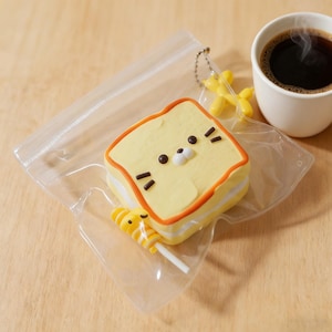 May include: A white ceramic mug with a black handle and the text "But First, Coffee" in a handwritten style. The mug is on a white surface. The mug is approximately 4 inches tall.