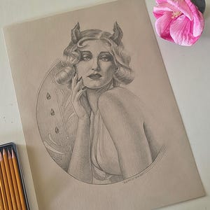 May include: A graphite drawing on tan paper depicting a person with short wavy hair and small horns. The figure is positioned within a circular frame featuring teardrop shapes and leaf motifs. The artwork is rendered in shades of grey and black.