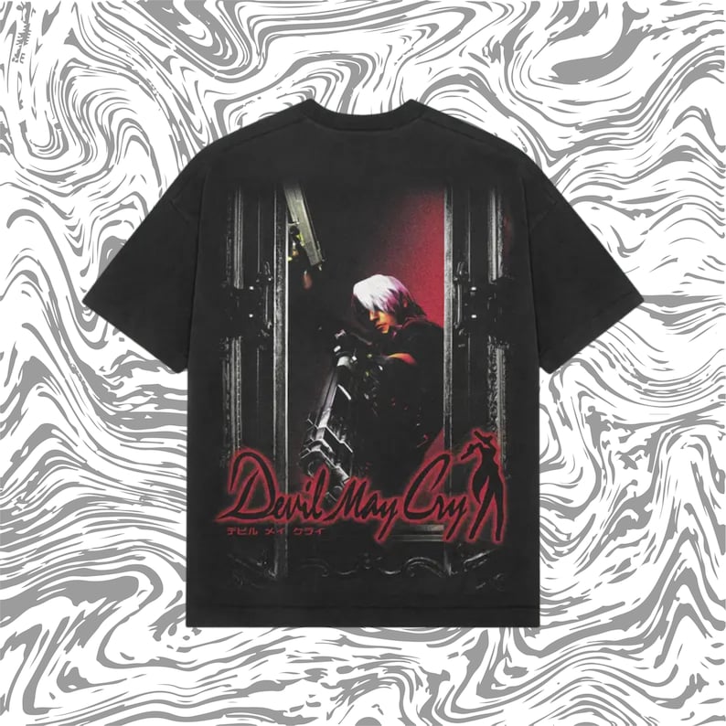 May include: Black t-shirt featuring a graphic from the video game "Devil May Cry." The design includes a character with white hair, a gun, and the game's logo in red. The Japanese text is also visible.