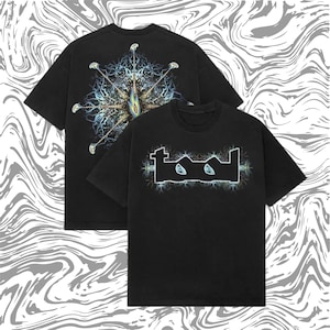 Puede incluir: Dos camisetas negras con la banda "TOOL". Una camiseta muestra el nombre de la banda en una fuente estilizada con un diseño de relámpago. La otra camiseta tiene un diseño complejo, colorido y simétrico en la espalda.