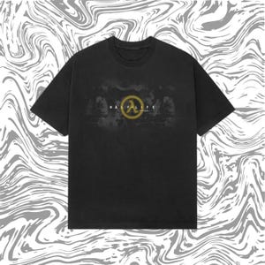 以下が含まれることがあります： 「HALF-LIFE」の文字と黄と黒のロゴが入った黒いTシャツ。ロゴは円の中の様式化されたラムダ記号です。Tシャツはクルーネックと半袖です。背景は渦巻くグレーと白の模様です。