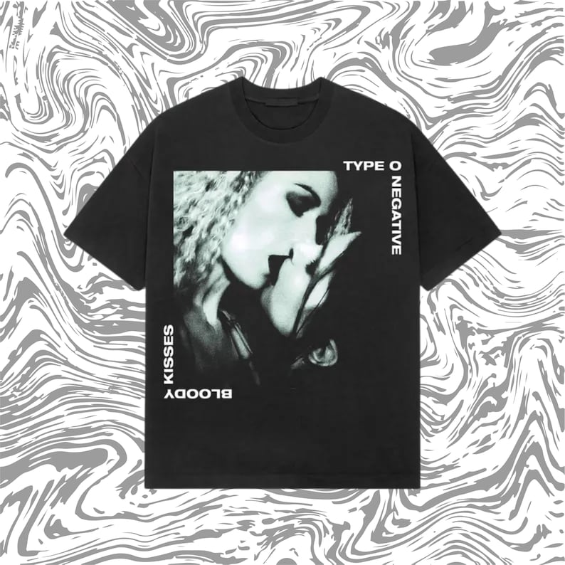 May include: Black t-shirt featuring a grayscale image of two people kissing. The text "TYPE O NEGATIVE" is printed vertically on the right side, and "BLOODY KISSES" is printed vertically on the left side of the image.
