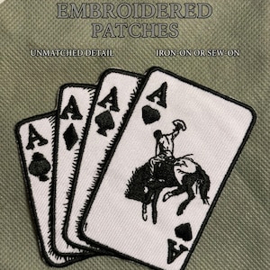 May include: Embroidered patches featuring playing cards, including three Aces of different suits and a fourth Ace with a cowboy riding a bucking bronco. The patches are white with black detailing and the text "EMBROIDERED PATCHES", "UNMATCHED DETAIL", and "IRON-ON OR SEW-ON".