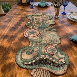 Camino de mesa costero con cuentas: Cuentas de vidrio con forma de concha marina, 33 x 91 cm.