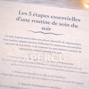 May include: A close-up of a beige card with French text. The text reads "Les 5 étapes essentielles d'une routine de soin du soir" and describes a skincare routine. The card has a textured surface and a wave design.