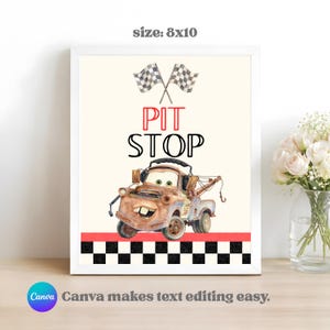 May include: A framed 20x25 cm print featuring a rusty brown tow truck character with large eyes and a wide smile. Above the truck, two crossed checkered flags appear. The text PIT STOP is printed in red and black. A black and white checkered border sits below.