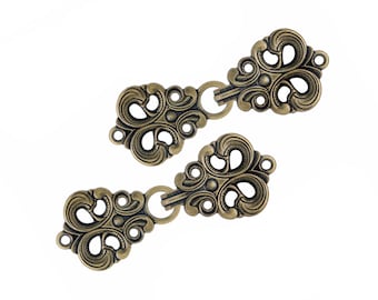 4 paia di ganci e occhielli da cucire in ottone anticato con motivo barocco a spirale per mantelli. Dimensioni: 70 mm x 25 mm.
