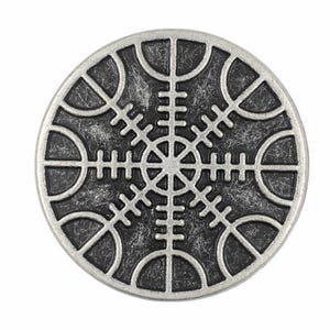 May include: A circular metal button featuring a raised silver-toned Vegvisir symbol against a dark, distressed, and textured background. The design consists of eight radiating staves with intricate cross-bar details, enclosed within a smooth, polished silver-toned circular border.
