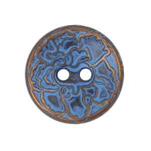 May include: A round, two-hole button featuring a textured surface with a light blue enamel inlay set against a metallic copper-toned base. The design consists of irregular, organic shapes that create a raised, intricate pattern across the face.