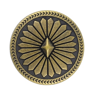 Peut inclure: Un bouton en métal doré avec un motif géométrique noir et or. Le bouton est de forme circulaire avec un centre surélevé et une bordure texturée.