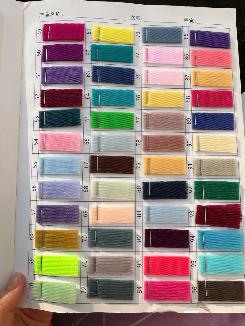 May include: A color swatch chart featuring forty-eight rectangular fabric samples of tulle mesh, each attached with a metal staple. The samples are arranged in a grid, numbered 49 through 96, displaying a wide variety of vibrant and pastel colors.