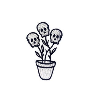 Puede incluir: Parche bordado que representa una maceta con tres flores con forma de calavera. Las calaveras tienen cuencas de los ojos y una cavidad nasal. La maceta tiene un diseño sencillo y texturizado. El parche es en blanco y negro.