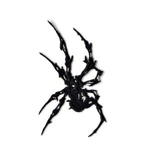 Può includere: Applicazione a forma di ragno nero con aspetto strutturato. L'applicazione presenta un design dettagliato con molteplici zampe e un corpo centrale, su sfondo bianco. Ideale per progetti di abbigliamento o artigianato.