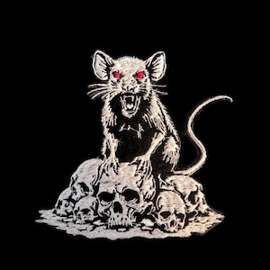 Op de afbeelding: Geborduurde patch met een witte rat met rode ogen, zittend op een stapel witte schedels. De rat heeft gedetailleerde vacht, en de schedels zijn ingewikkeld ontworpen. De achtergrond is effen zwart, wat het contrast van de afbeelding versterkt.