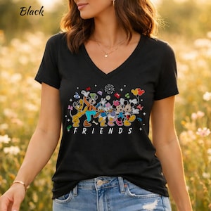 May include: A black V-neck t-shirt featuring a colorful graphic of cartoon characters including Pluto, Goofy, Donald Duck, Daisy Duck, Minnie Mouse, and Mickey Mouse. The word FRIENDS is printed in white capital letters below the characters.