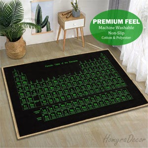 May include: Black rectangular rug featuring the periodic table of elements in green lettering. The rug is made of cotton and polyester and has a non-slip backing. The rug has a beige border and is machine washable.