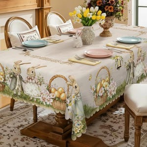 Puede incluir: Un mantel beige con temática de Pascua con ilustraciones de conejos, cestas de huevos y arreglos florales. El mantel está puesto sobre una mesa de madera con cubiertos, incluyendo platos, cubiertos y cojines decorativos.