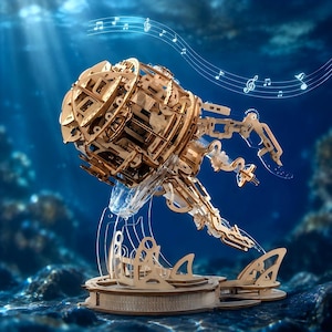 May include: A mechanical jellyfish model constructed from light-coloured wood pieces, featuring intricate gears and articulated tentacles. The structure is mounted on a clear acrylic base with a circular platform, set against a deep blue underwater background.