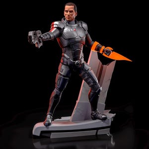 May include: A detailed figurine of a character in a futuristic armored suit, holding a gun and a glowing orange blade. The figure stands on a gray platform with a futuristic design. The suit is primarily dark gray with red and white accents.