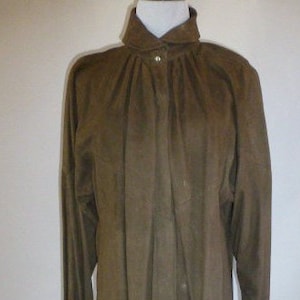 May include: A brown suede button-up shirt with a high collar and long sleeves.