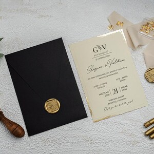 Juego de invitaciones de boda con detalles en lámina de oro, sello de cera personalizado y sobre elegante.