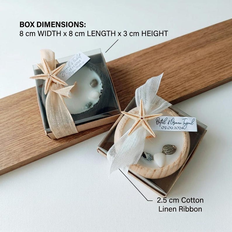 Puede incluir: Dos cajas de regalo cuadradas de 8 cm de ancho, 8 cm de largo y 3 cm de alto, cada una con una vela redonda de cera blanca, conchas peque&ntilde;as y una estrella de mar. Una cinta de lino y algod&oacute;n de 2,5 cm rodea cada caja con una etiqueta.