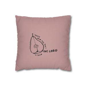 Könnte beinhalten: Ein quadratisches, staubrosa Kissen mit einer schwarzen Illustration einer Birne und dem schwarzen Schriftzug "Taste and see that the LORD is good". Es ist ein dekorativer Artikel.