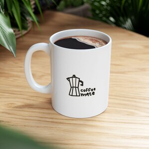 Könnte beinhalten: Ein Set aus drei Keramikbechern mit gesprenkelter, matter Oberfläche. Die Becher sind in den Farbtönen Creme, Hellgrau und Dunkelgrau gehalten. Jeder Becher hat ein schlichtes, minimalistisches Design, ideal für Kaffee oder Tee.