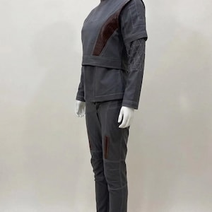 May include: A white ceramic mug with a black handle and the text "But First, Coffee" in a black, bold font. The mug is sitting on a wooden surface. The mug is approximately 4 inches tall.