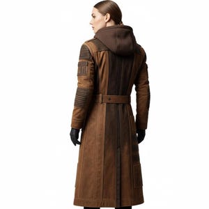 May include: A long brown coat with a hood, belt, and multiple pockets. The coat has a textured appearance with darker brown panels down the center and on the sleeves. The sleeves have horizontal stitched detailing. The model is wearing black gloves.