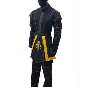 May include: Black costume with yellow detailing, including a high collar and a unique emblem. The outfit comprises a long-sleeved top, trousers, and an apron-style element. The costume features white stitching.